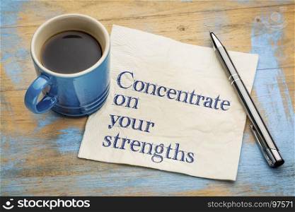Concentrate on your strengths - handwriting on a napkin with a cup of espresso coffee