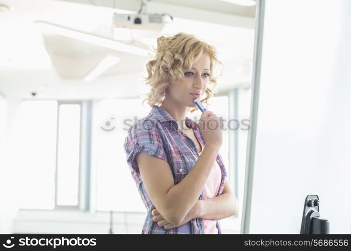 Concentrated businesswoman looking at presentation board in creative office