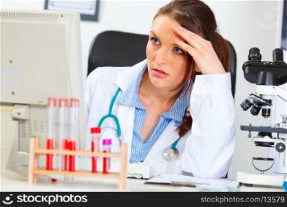 Concentrated doctor woman sitting in office and working on computer&#xA;