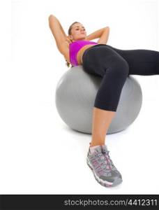 Concentrated fitness young woman doing abdominal crunch on fitness ball