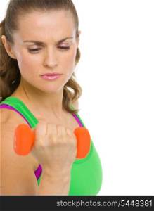 Concentrated fitness young woman making exercise with dumbbells