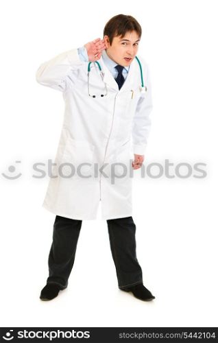 Concentrated medical doctor holding hand at ear and listening isolated on white&#xA;