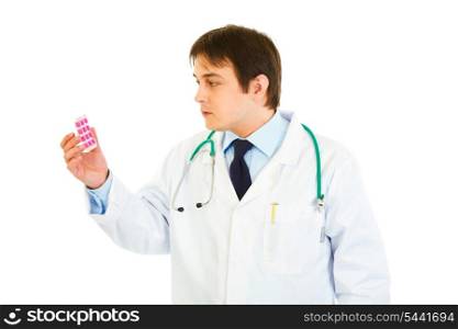 Concentrated medical doctor looking on pills pack isolated on white&#xA;