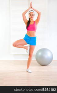 Concentrated pretty girl doing yoga exercises&#xA;