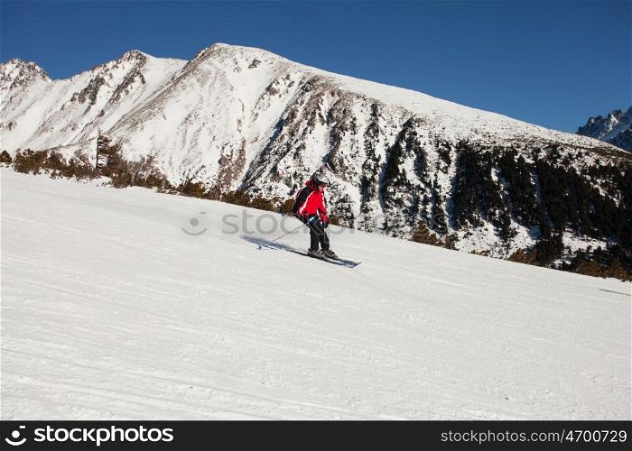 Concentrated skier descends from the mountain top. Skier in the mountains