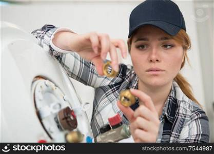 concentrated woman fixing a boiler