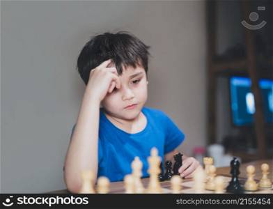 Concentrated Young boy developing chess strategy, playing board game with parent at home. Activity or Hobby for Family Concept