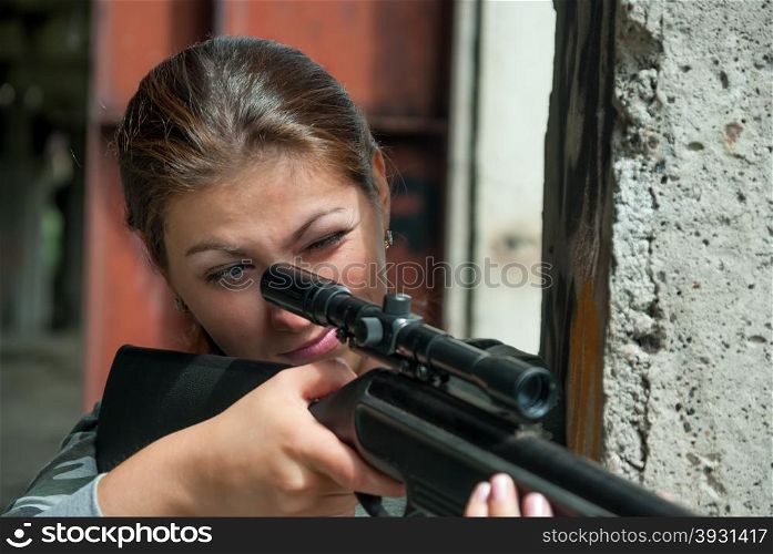 concentrated young brunette looking in rifle sight