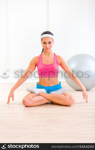 Concentrated young girl practising yoga exercises on floor at living room &#xA;