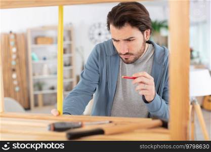 concentrated young man assembling furniture