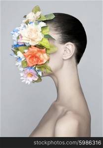 Concept fashion studio portrait of nude elegant lady with flower on her face