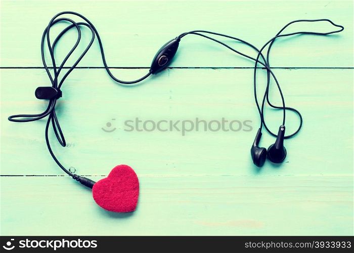 Concept for love music. Earphones connected to the heart. Image toned with retro filter.