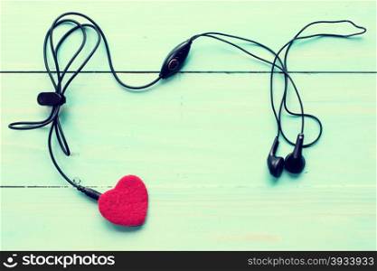 Concept for love music. Earphones connected to the heart. Image toned with retro filter.