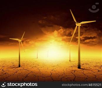 Concept of alternative electricity power with windmills on sunset background. Alternative wind energy