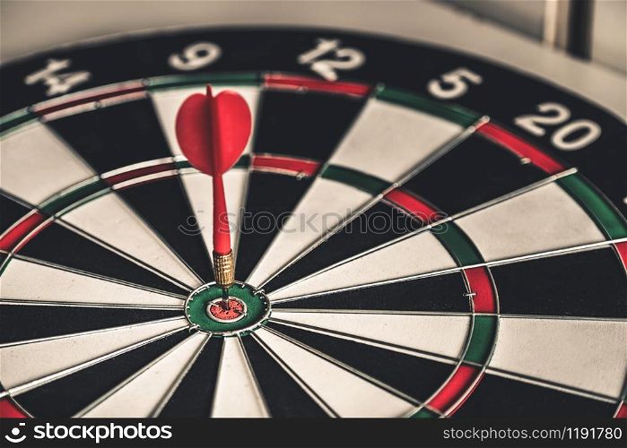 Concept of challenge in business marketing bullseye and intelligent customer reaching. The dart is the strategy or skill. The dartboard is the target or goal.