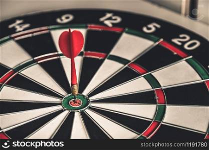 Concept of challenge in business marketing bullseye and intelligent customer reaching. The dart is the strategy or skill. The dartboard is the target or goal.