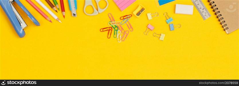 Concept of education top view notebooks and accessories stationery in the library at school yellow background