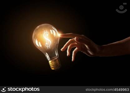 Concept of electric energy. Close up of human hands touching with finger light bulb