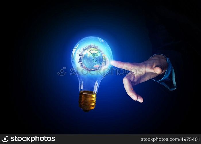 Concept of electric energy. Close up of human hands touching with finger light bulb. Elements of this image are furnished by NASA