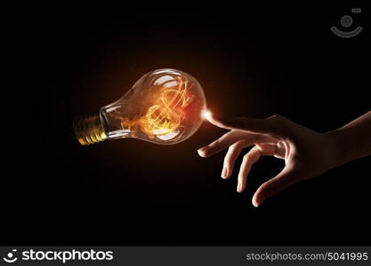 Concept of electric energy. Close up of human hands touching with finger light bulb