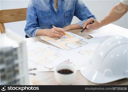 Concept of engineering consulting, Male engineer is explaining blueprint of building to colleague.