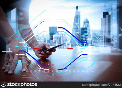 Concept of focus on target with digital diagram.designer hand working and smart phone and laptop on wooden desk in office with london city background