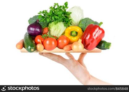 Concept of healthy food serving service - female hand holding a wooden board with various vegetables on a white background in close-up (composite image)