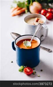Concept of healthy vegetable and legume soups. Pea and tomato soups and ingredients. Pea and tomato soups and ingredients on concrete background