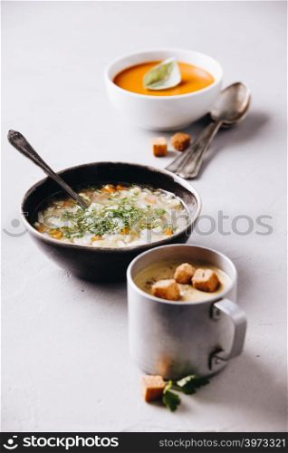 Concept of healthy vegetable and legume soups. Pea, tomato, vegetable soups and ingredients. Pea, tomato, vegetable soups and ingredients on concrete background