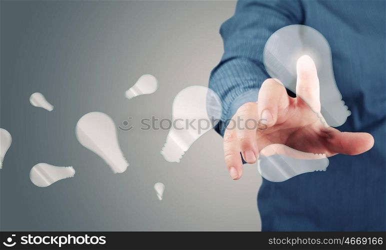 Concept of idea or creativity. Close up of businessman touching with finger virtual light bulb