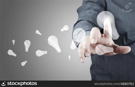 Concept of idea or creativity. Close up of businessman touching with finger virtual light bulb