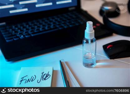 Concept of loss and searching job by reason of coronavirus covid-19. Sanitizer anti virus spray on the working table with laptop.. Sanitizer anti virus spray