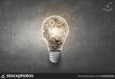 Concept of mechanism light bulb with gears inside. Light bulb with cogwheels