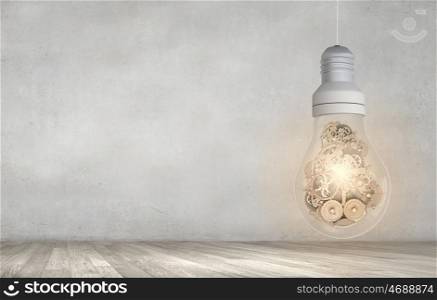 Concept of mechanism light bulb with gears inside. Light bulb with cogwheels