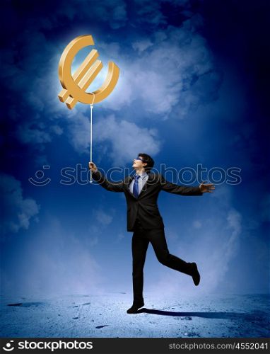 Concept of money. Image of businessman catching euro symbol. Currency concept