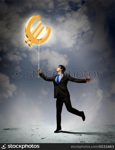 Concept of money. Image of businessman catching euro symbol. Currency concept