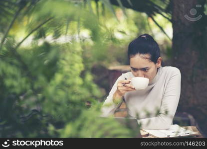 Concept of morning coffee and breakfast in an outdoor cafe. Hands of an unidentified young woman
