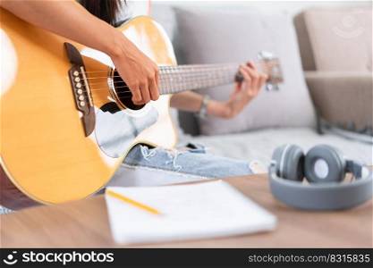 Concept of relaxation with music, Young asian woman playing music with lyrics and acoustic guitar.