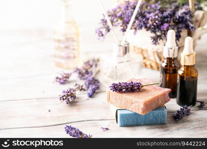 Concept of spa with natural organic oil. Moisturizing skin care and aromatherapy. Gentle body treatment. Handmade soap bars. Atmosphere of harmony, relax. White wooden background, lavender flowers. Handmade soap bars