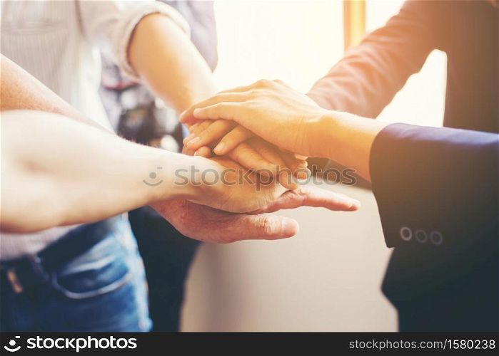 Concept of teamwork: Close-Up of hands business team showing unity with putting their hands together.