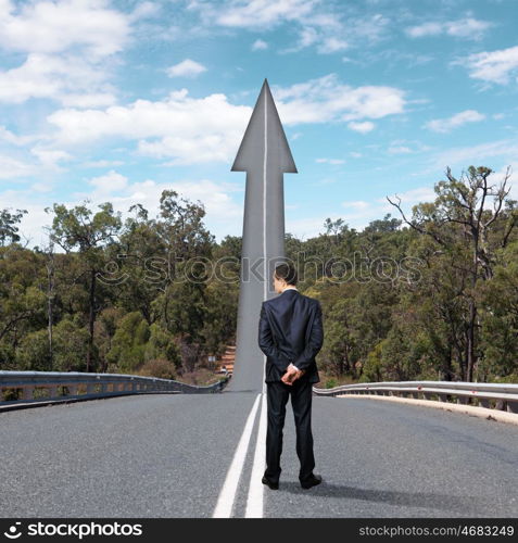 Concept of the road to success. Concept of the road to success with a businessman standing on the road