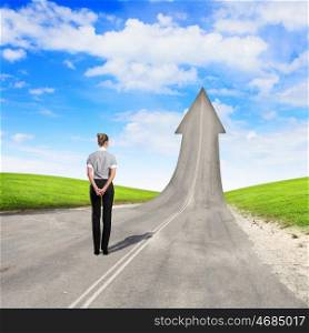 Concept of the road to success. Concept of the road to success with a businesswoman standing on the road
