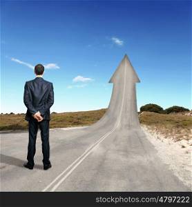 Concept of the road to success. Concept of the road to success with a businessman standing on the road