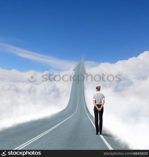 Concept of the road to success. Concept of the road to success with a businesswoman standing on the road