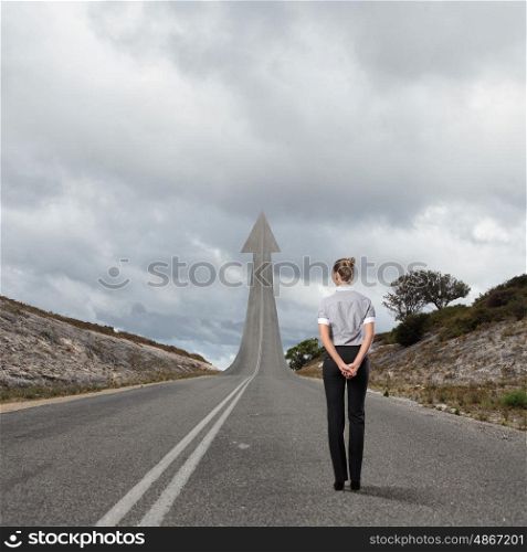 Concept of the road to success. Concept of the road to success with a businesswoman standing on the road