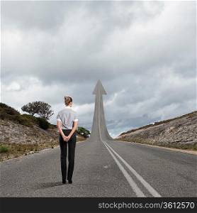 Concept of the road to success with a businesswoman standing on the road