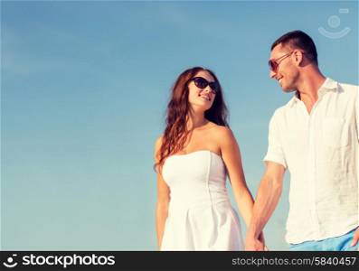 concept - smiling couple wearing sunglasses walking outdoors. smiling couple in city