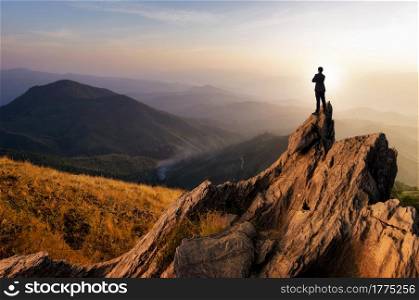 Concept vision, Young businessman wearing comfortable casual suit jacket standing chest hug on top of peak mountain and looking forwards, success, competition and leader concept.. businessman looking forwards.
