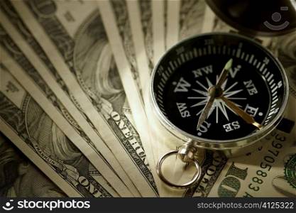 concept with dollars and compass, selective focus on nearest part of arrow