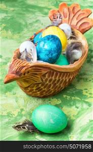 Concept with Easter eggs. Easter colored egg in a wooden symbolic chicken